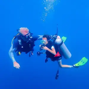 Instructor assisting a student during their first Open Water dive in Bali.