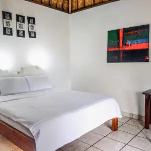 Clean bungalow bedroom with double bed, traditional bamboo ceiling, and modern amenities at Tulamben dive resort