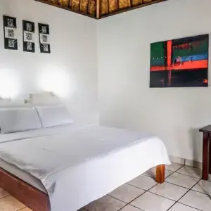 Clean bungalow bedroom with double bed, traditional Balinese bamboo ceiling at Ocean Sun Dive Resort Tulamben