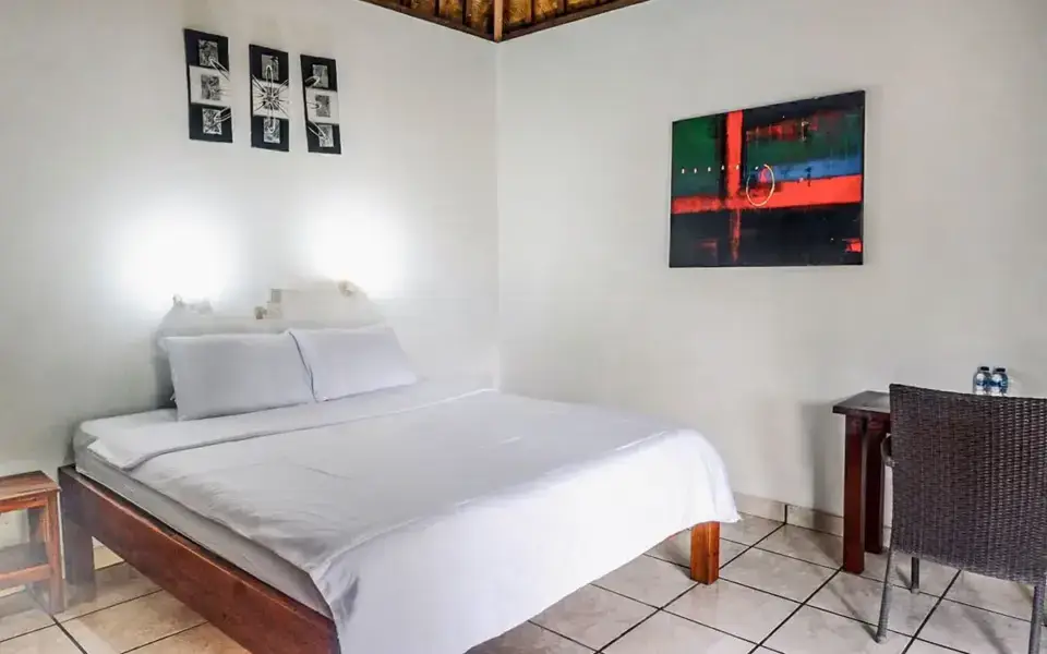 Clean bungalow bedroom with double bed, traditional Balinese bamboo ceiling at Ocean Sun Dive Resort Tulamben