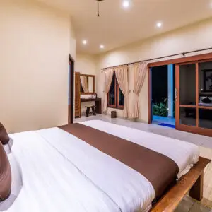 Luxurious bungalow bedroom at Ocean Sun Dive Resort Tulamben with pool view and modern Balinese decor