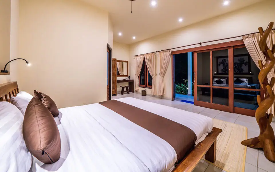 Luxurious bungalow bedroom at Ocean Sun Dive Resort Tulamben with pool view and modern Balinese decor