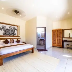 Spacious bungalow bedroom with double bed, wardrobe and desk at Ocean Sun Dive Resort in Tulamben