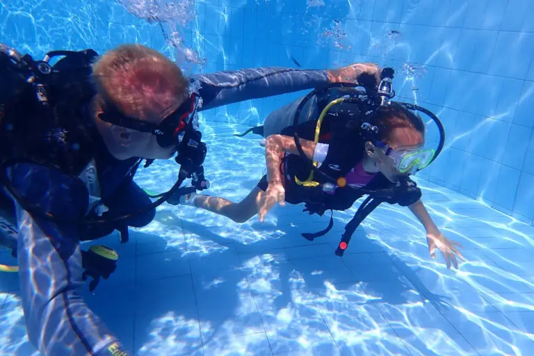 Tauchlehrer unterrichtet Anfänger im Pool des Tauchzentrums in Tulamben, Bali