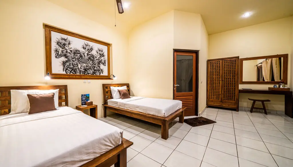 Twin bed bungalow room at Ocean Sun Dive Resort Tulamben with wooden furniture and traditional Balinese decor