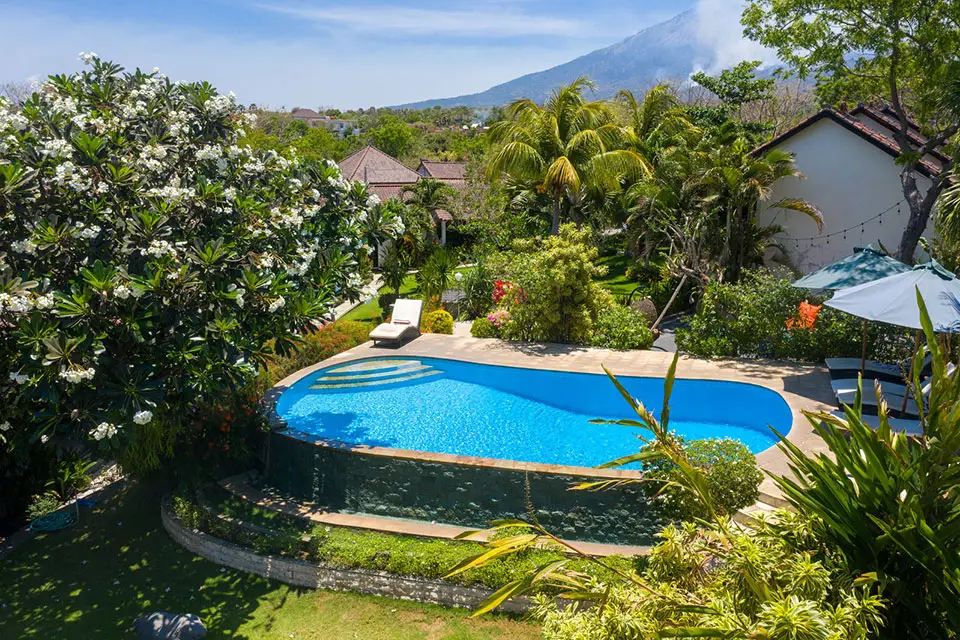 Swimming pool at Ocean Sun Dive Resort Tulamben with Mount Agung volcano view and tropical garden
