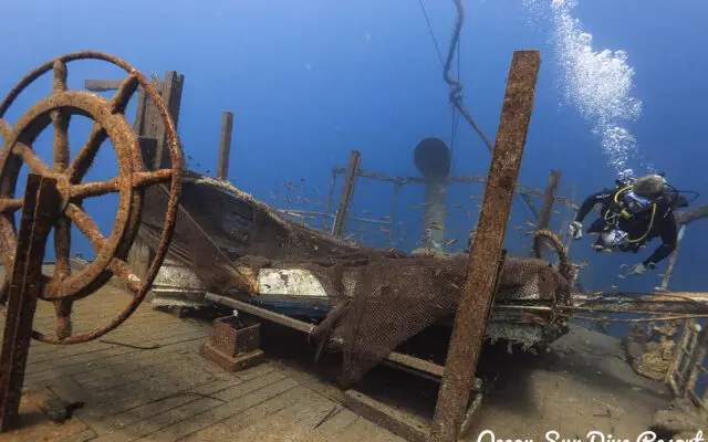 Taucher erkundet den Heckbereich des USAT Liberty Schiffswracks mit Steuerrad in Tulamben, Bali