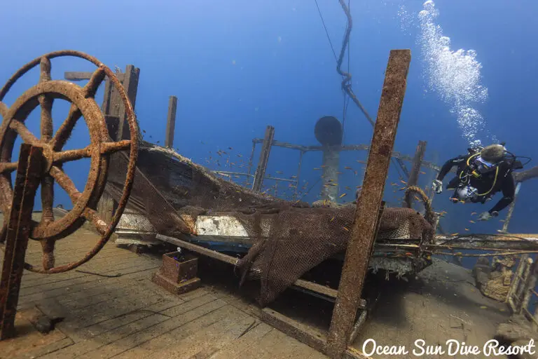 Taucher erkundet den Heckbereich des USAT Liberty Schiffswracks mit Steuerrad in Tulamben, Bali