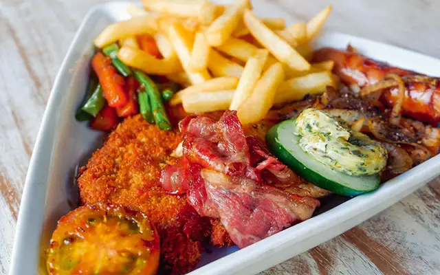 Schnitzel with crispy bacon, french fries, and fresh vegetables served at Ocean Sun Dive Resort restaurant Tulamben